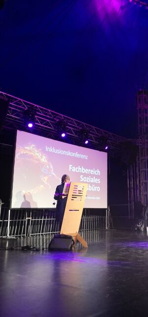 Eine Person auf einer Bühne hinter einem Rednerpult