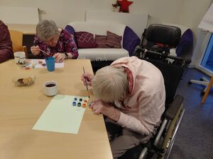 Eine Person am Tisch malt.