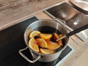 EIn Topf mit Glühwein und Orangen.