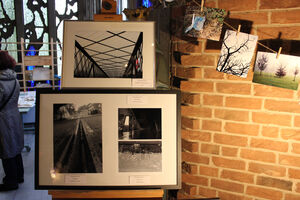 Schwarz weiss bilder in Rahmen, bunte Bilder an einer Leine an der Wand.