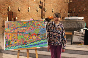 Eine Frau steht neben einem bunten Bild.