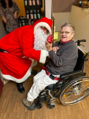 Der Nikolaus bei einer Person im Rollstuhl.