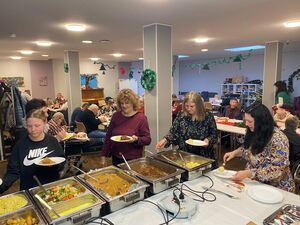 Mehrere Personen stehen an einem Buffet an.