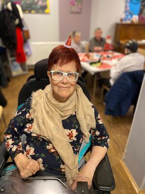 Eine Frau im Rollstuhl mit Brille.