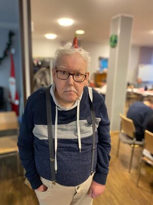 Ein Mann mit Brille und Hosenträgern.