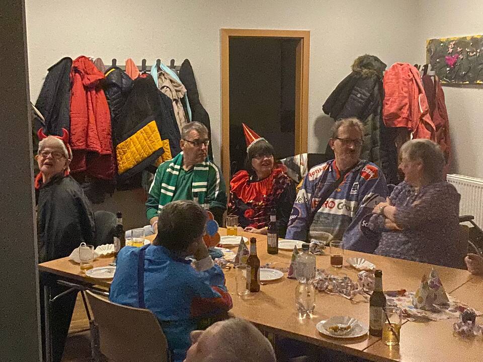 Mehrere Personen sitzen an einem langen Tisch.