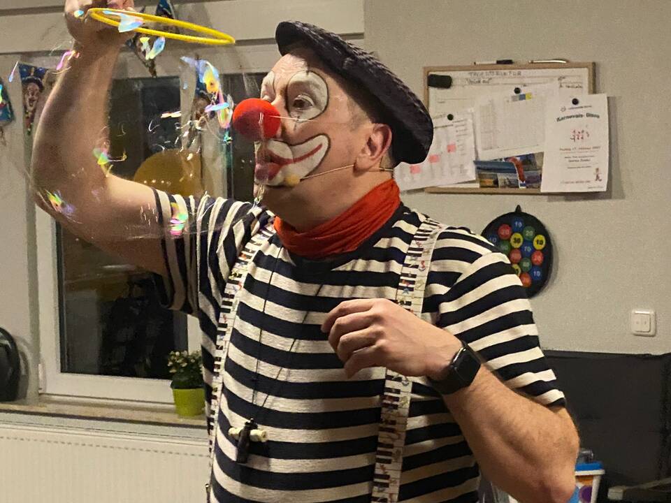 Ein Clown macht Seifenblasen.