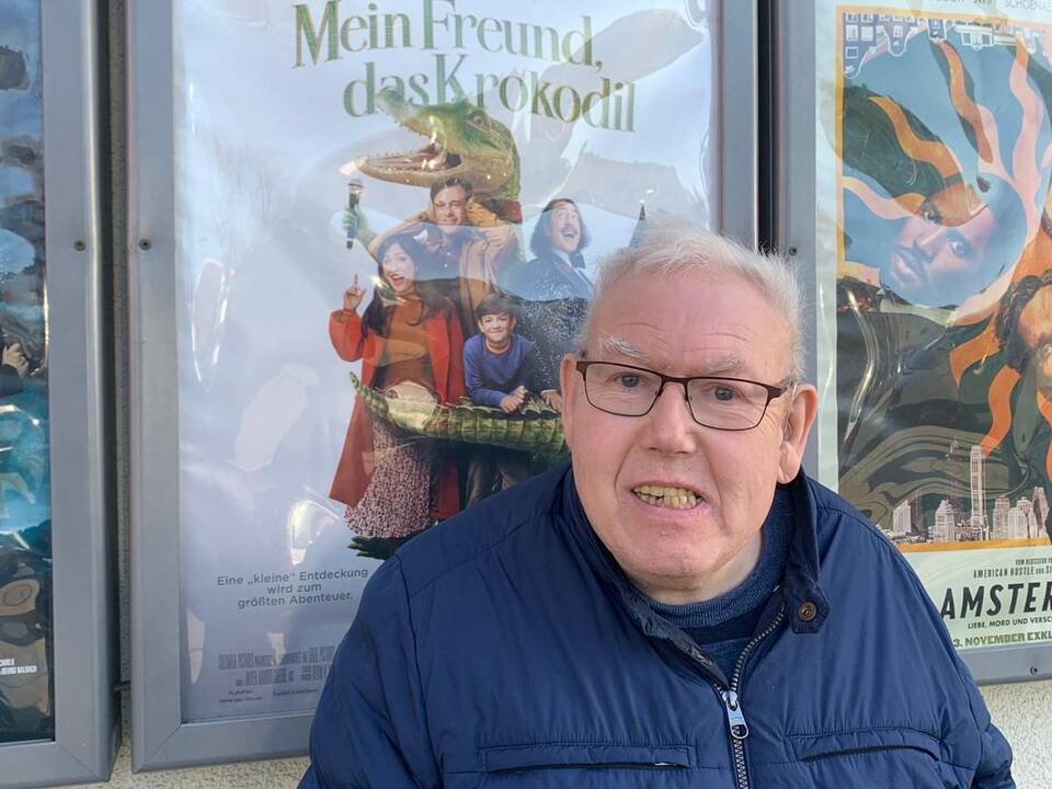 Ein Mann vor dem Plakat eines Filmes.