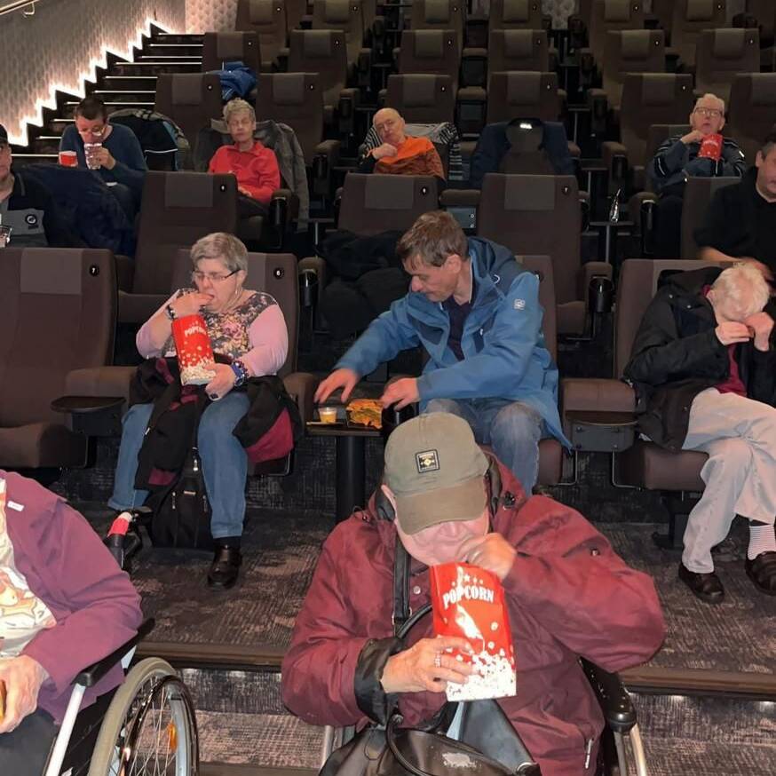 Me3nschen mit und ohne Rollstuhl im Kinosaal.