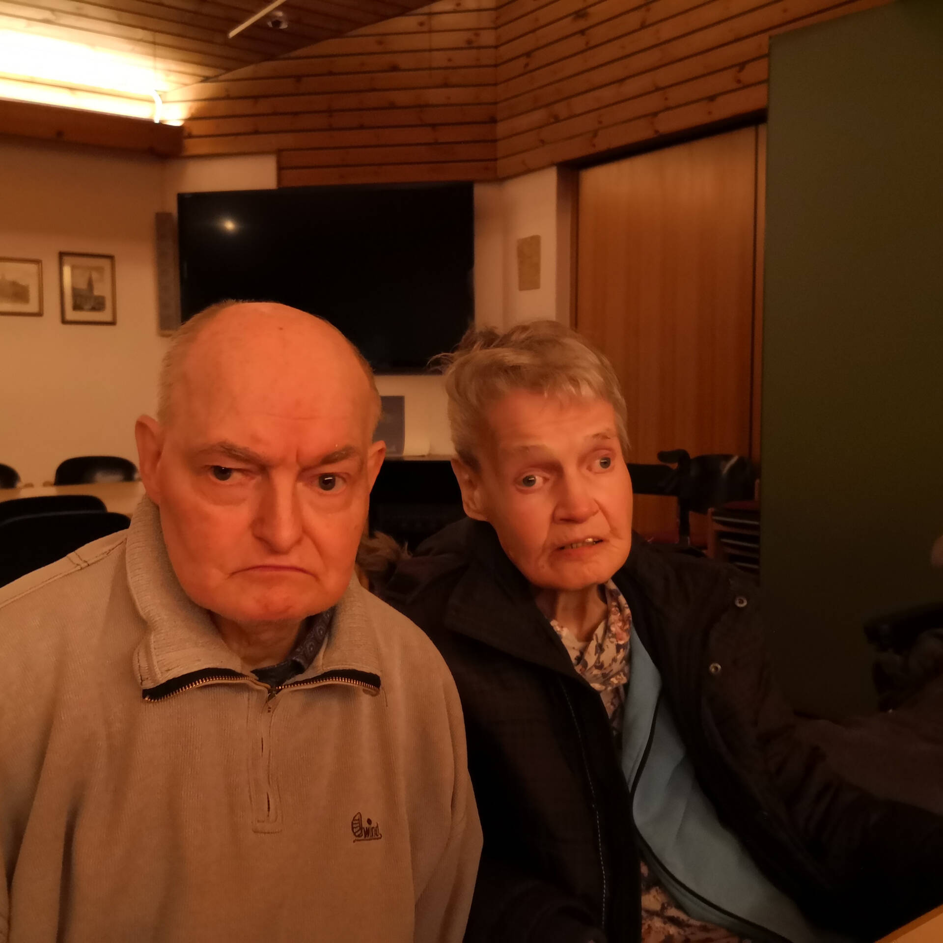 Ein Mann und eine Frau sitzen in einem Raum.