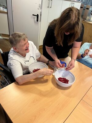 Zwei Personen am Tisch die Obst sortieren.
