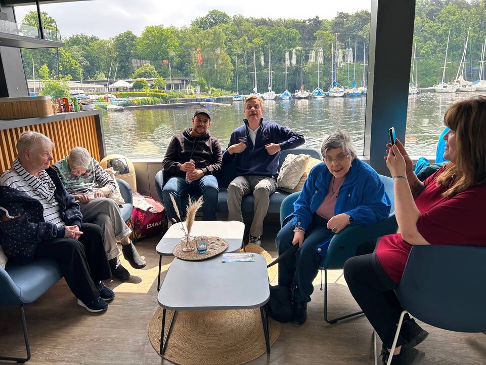 Mehrere Personen sitzen im Kreis zusammen.