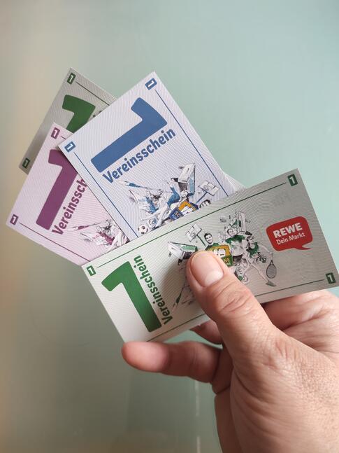 Eine Hand hält scheine für Vereine.