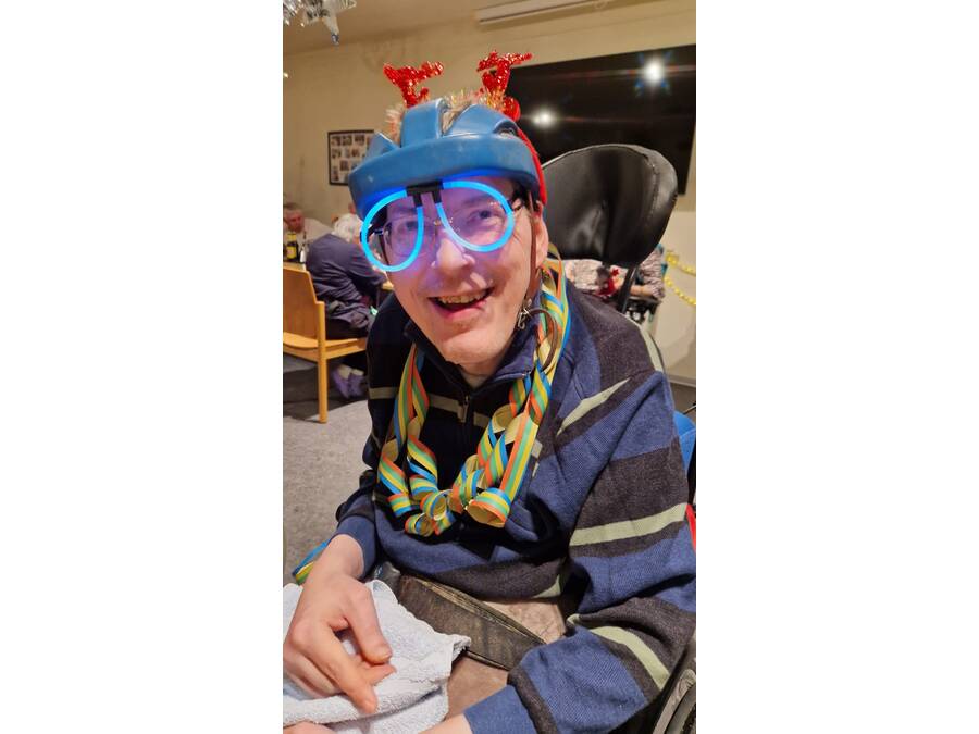 Mann mit Luftschlangenkette und leuchtender Brille